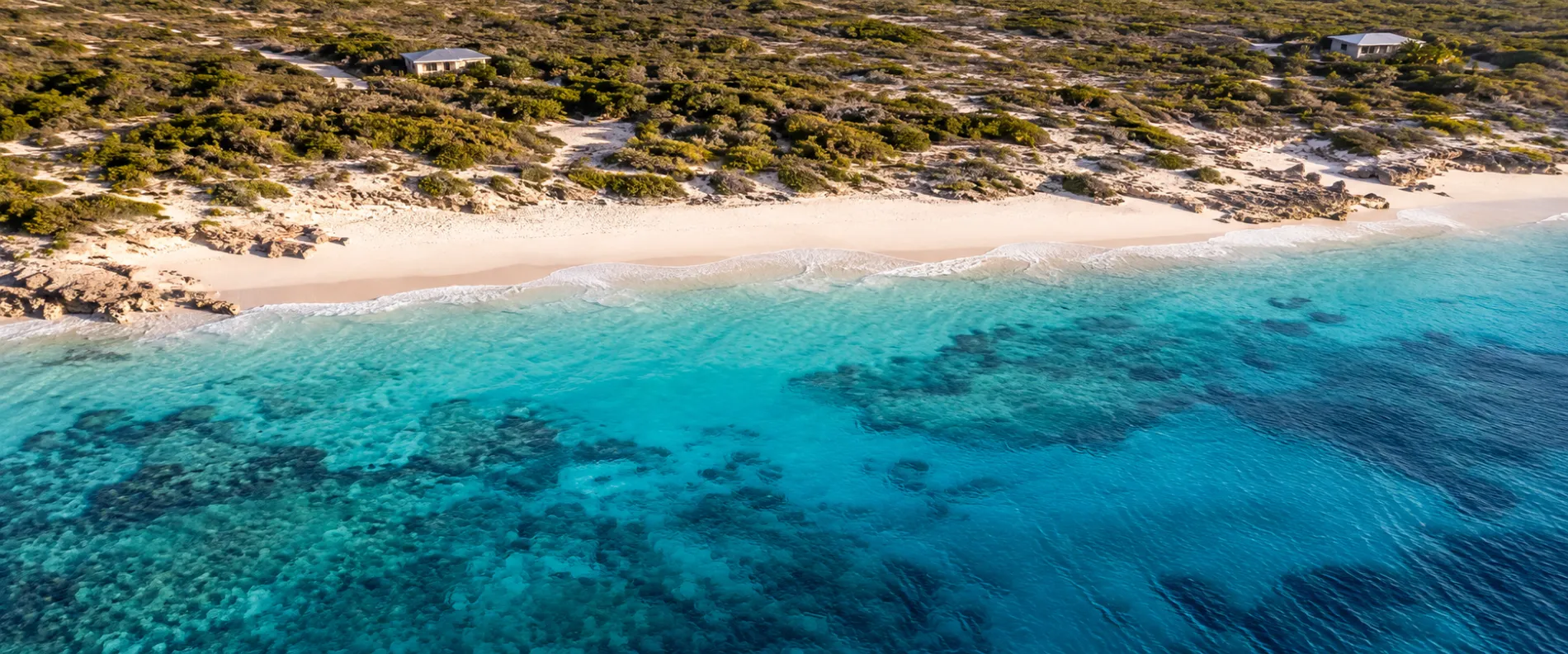 The Anguilla shoreline from the air — white sand and pale turquoise over reef